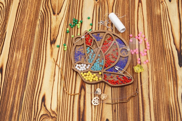 zestaw nici i igieł na drewnianej desce